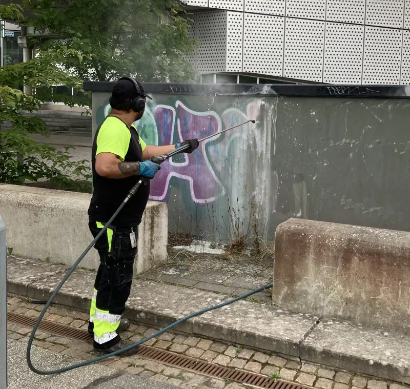 Man som rengör klotter på elcentral