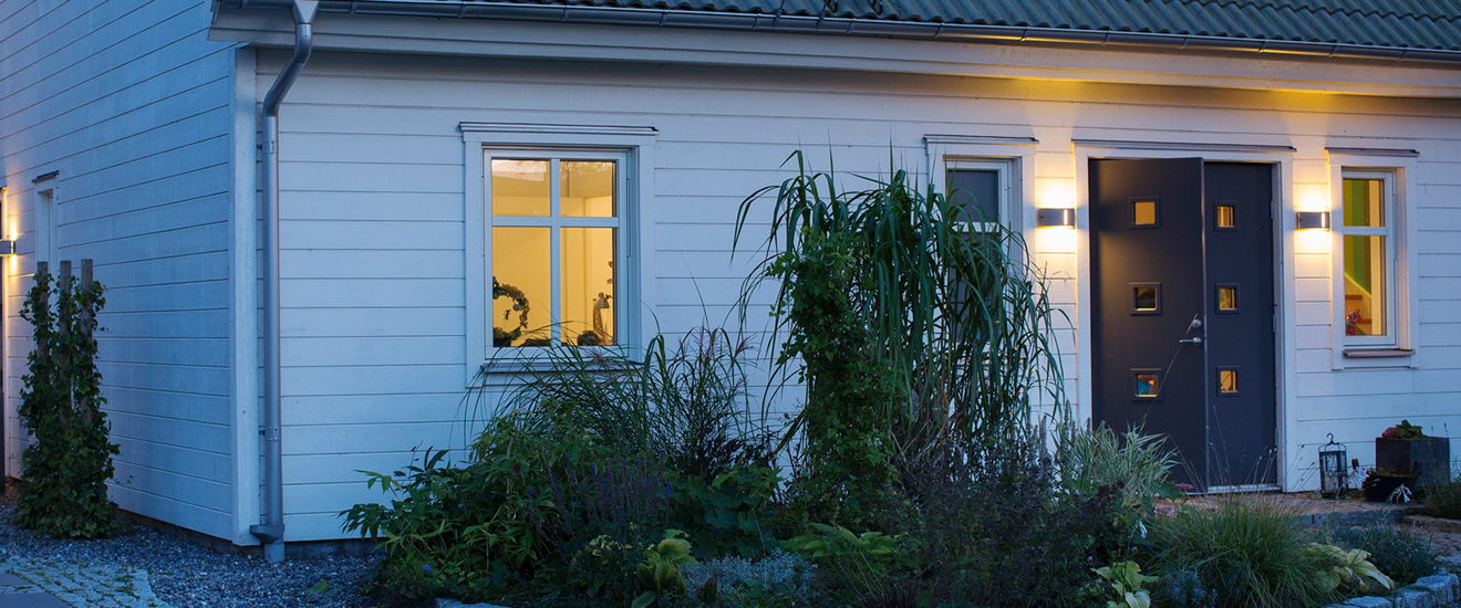 en vit fristående villa i skymning