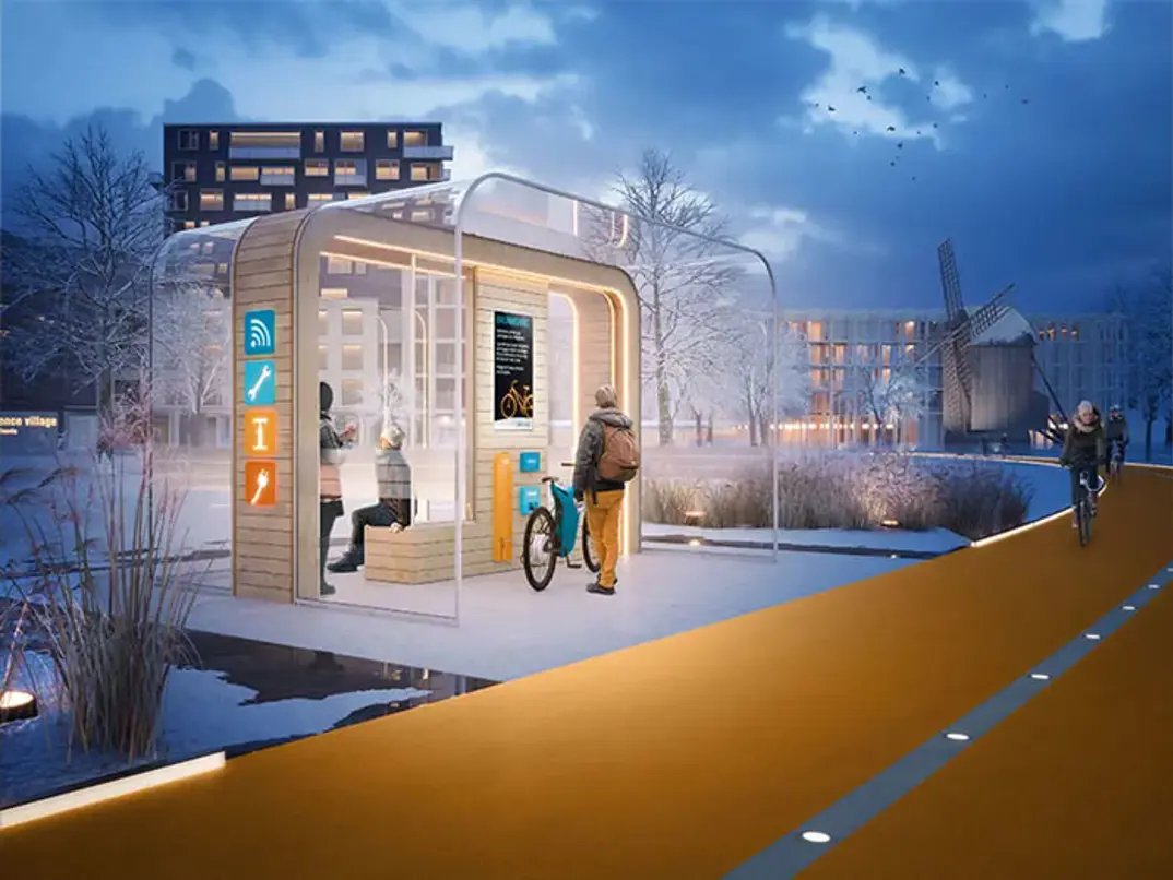 Visionsbild. Belyst hållplats i stadsmiljö, vinterväder med snö på marken. Snöfri cykelbana intill.