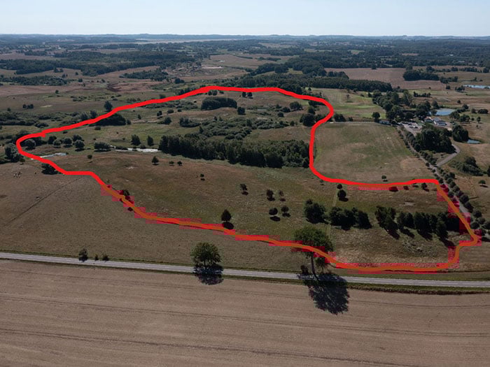 Drönarvy över golfbana med röd markering för tänk solpark.